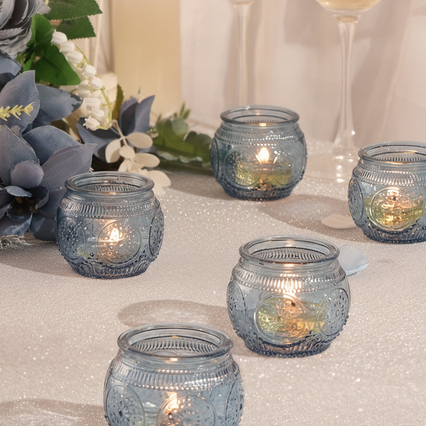 Blue glass votive candle holder on a bedroom nightstand creating a soft calming glow