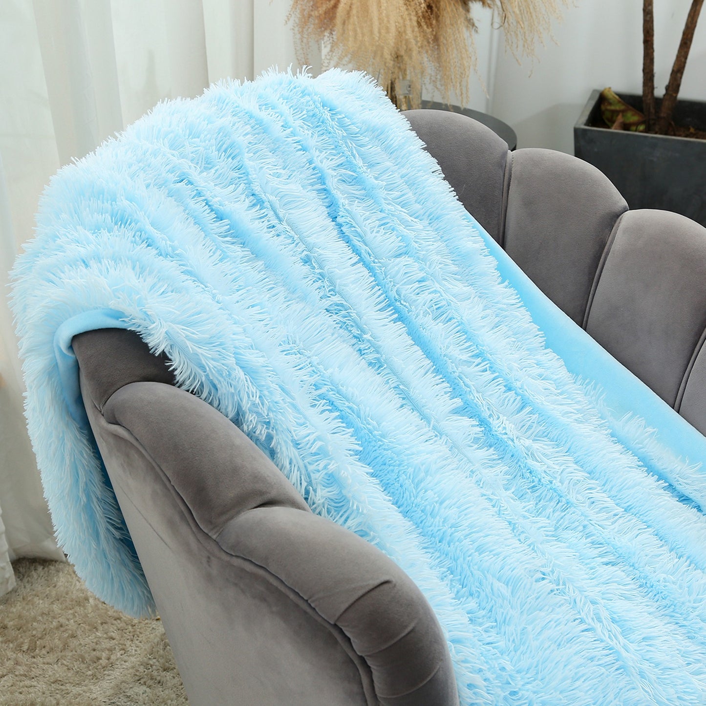 Cozy_cool_blue_plush_flannel_throw_blanket_adding_a_serene_calming_aesthetic_to_a_modern_living_room
