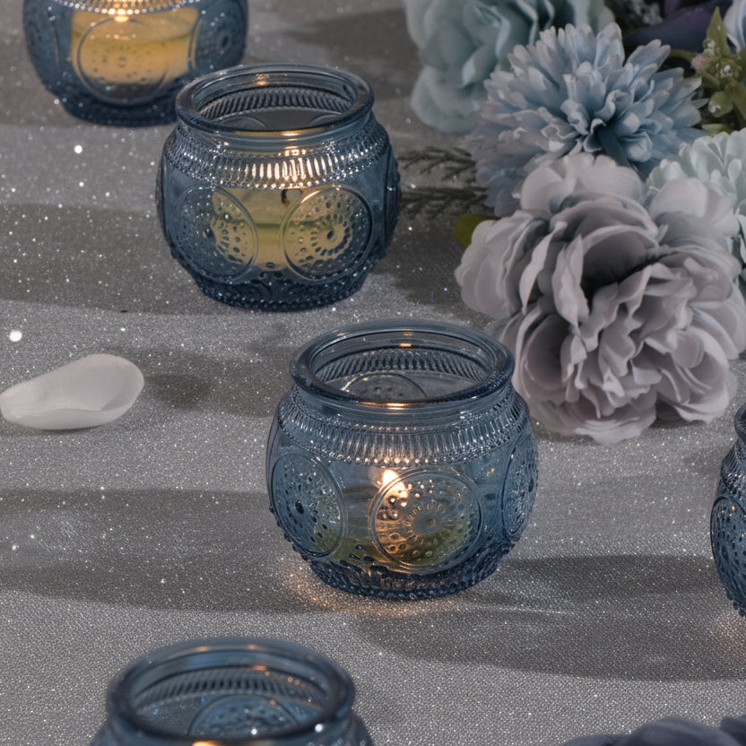 Modern blue glass votive candle holder styled with a minimalist cool toned background