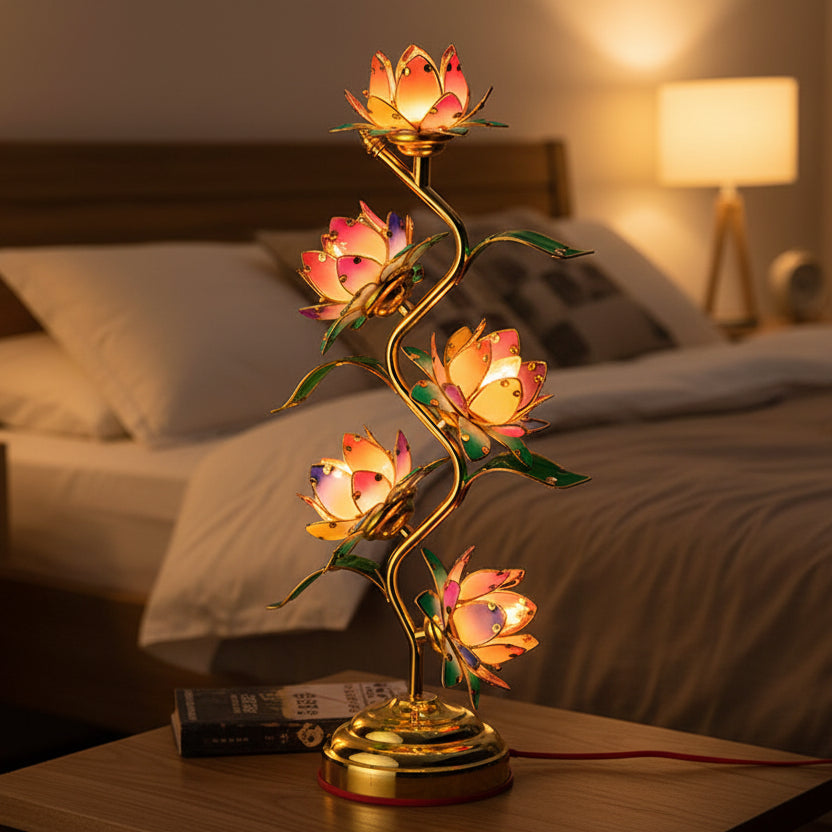 Soft pink lotus flower lamp glowing warmly on a bedside table.